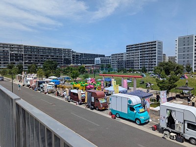 聳え立つ団地　列をなすキッチンカー